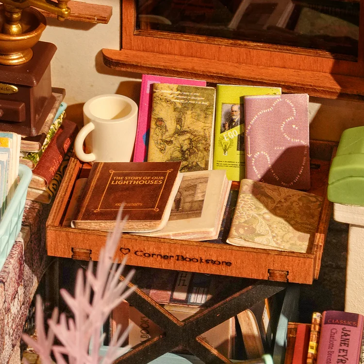Fully assembled Rolife Corner Bookstore miniature with books and a coffee cup on a wooden table.
