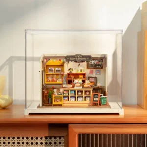 DIY miniature house of a charming bakery shop, encased in a clear display case, beautifully positioned on top of a wooden console cabinet.