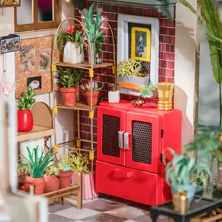 Close-up of Rolife Emily's Flower Shop Miniature House showing the charming assortment of miniature potted plants, shelves, crates, furniture, tools, and elements meticulously crafted to capture the essence of a real flower shop.