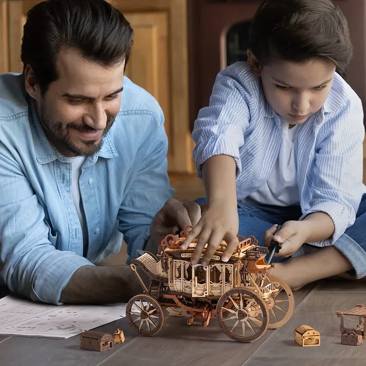 Father and child moving the ROKR Stagecoach Mechanical Music Box across a table.