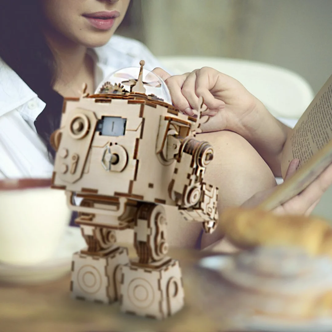 A woman assembling a DIY 3d wooden puzzle of a steampunk robot, which is also a music box.