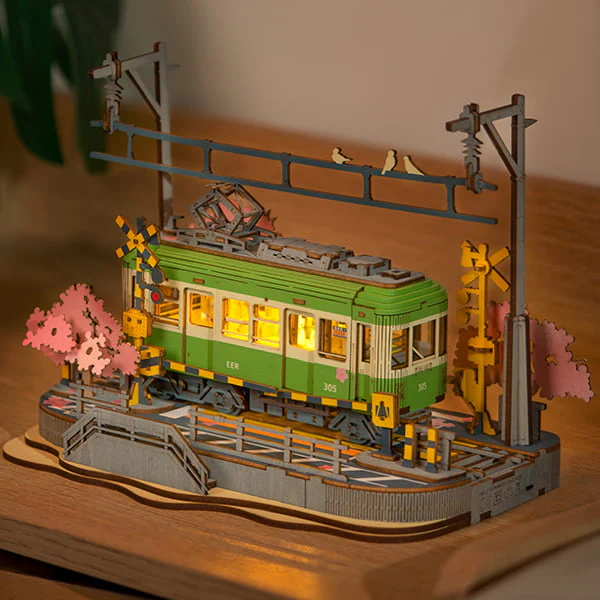 Fully assembled Sakura Journey 3D Wooden Puzzle with LED lights on a wooden table.