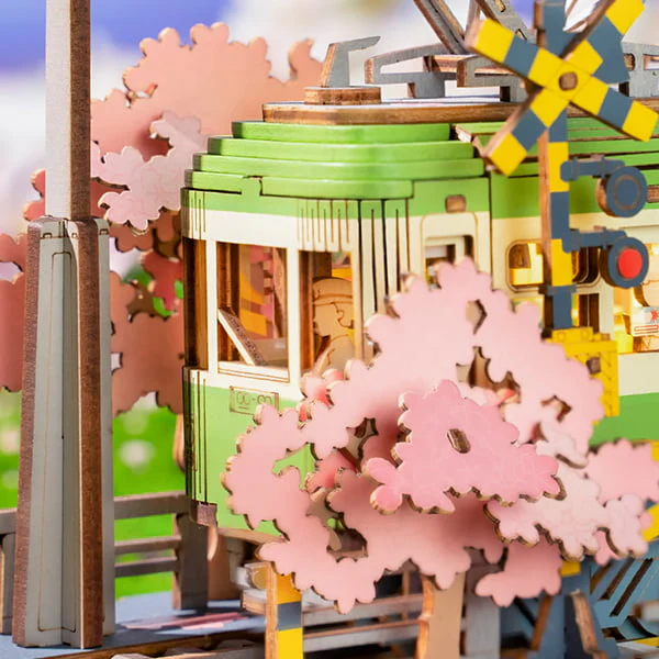 Close-up of the Sakura Journey 3D Wooden Puzzle train with pantograph, tracks, cherry blossoms, and crossing lights.