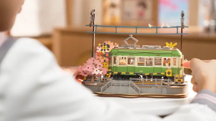 Fully assembled Sakura Journey 3D Wooden Puzzle on a white table with a blurred background.