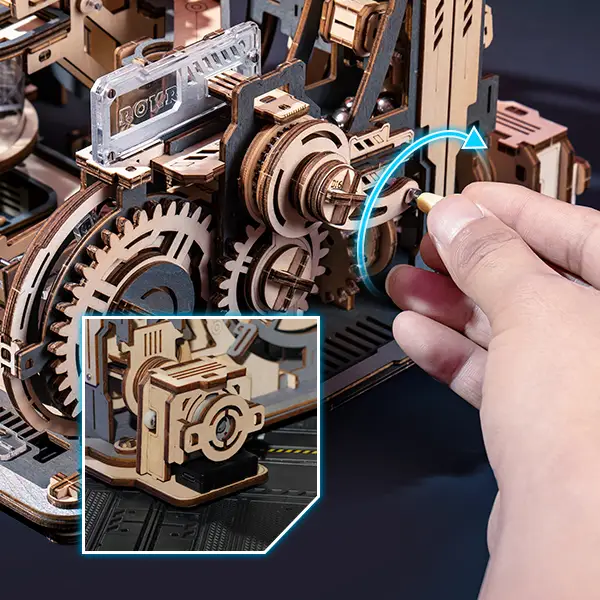 Hand turning the handle of the ROKR Marble Spaceport 3D Puzzle, demonstrating manual and electric modes.