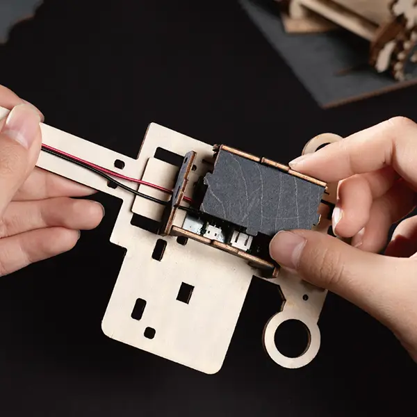 Hands assembling the ROKR Marble Spaceport 3D Wooden Puzzle, showcasing precise structures with no glue required.